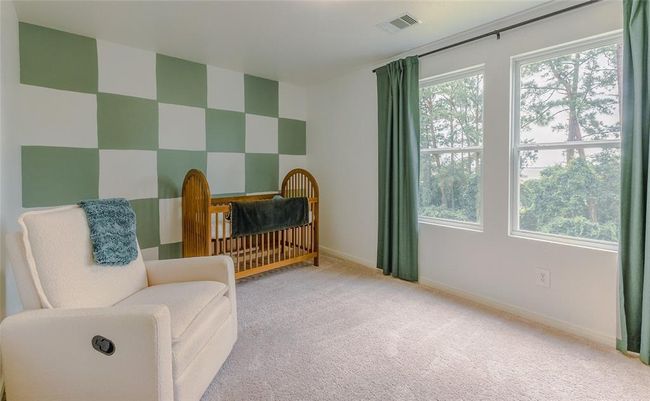 One of four bedrooms in this home, currently being used as a nursery, with a tastefully done feature wall! Bedroom located on the second floor with a view of green space and "BIG WATER!" Nicely sized walk in closet as well. | Image 25