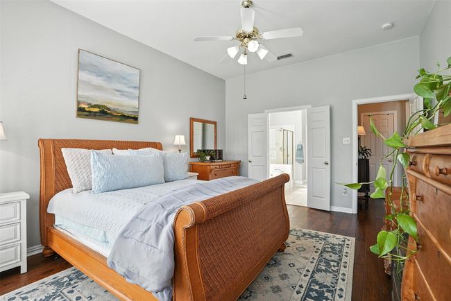 Bedroom featuring wood-type flooring, ceiling fan, and ensuite bath | Image 17