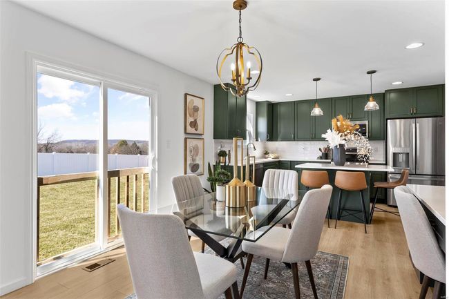 Dining room with light hardwood / wood-style flooring and a notable chandelier | Image 28