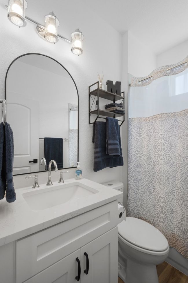 Bathroom with toilet, a shower with shower curtain, vanity, and wood finished floors | Image 21