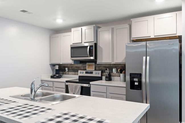 Kitchen with tasteful backsplash, stainless steel appliances, sink, and gray cabinetry | Image 8