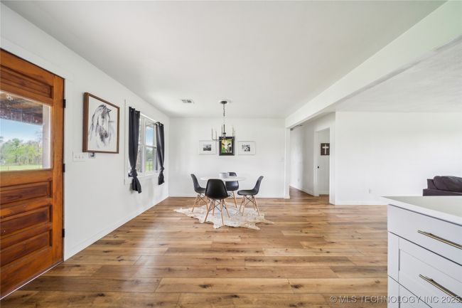 Dining room featuring light wood-style floors, a chandelier, and baseboards | Image 20