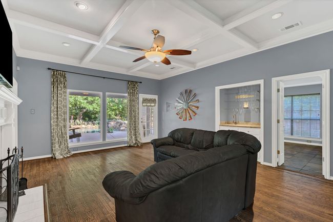 Living area featuring ceiling fan, healthy amount of natural light, coffered ceiling, beam ceiling, and dark wood-style flooring | Image 8