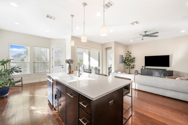 Kitchen with open floor plan, a kitchen bar, dark wood-style floors, light countertops, and recessed lighting | Image 26