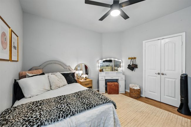 Bedroom featuring light wood finished floors, a closet, and a ceiling fan | Image 35