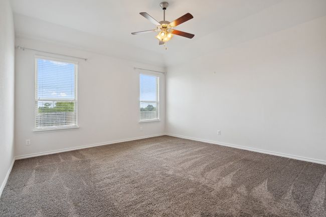 Carpeted spare room featuring a ceiling fan and baseboards | Image 15