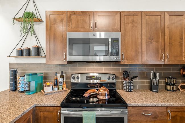 Kitchen with appliances with stainless steel finishes, brown cabinets, and backsplash | Image 31