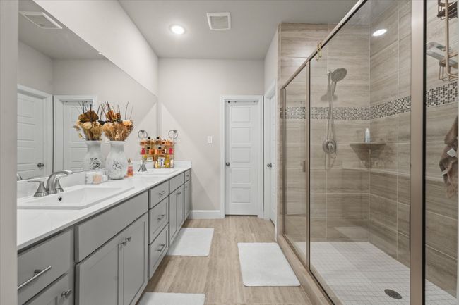 Full bath with double vanity, wood finished floors, a shower stall, and recessed lighting | Image 25