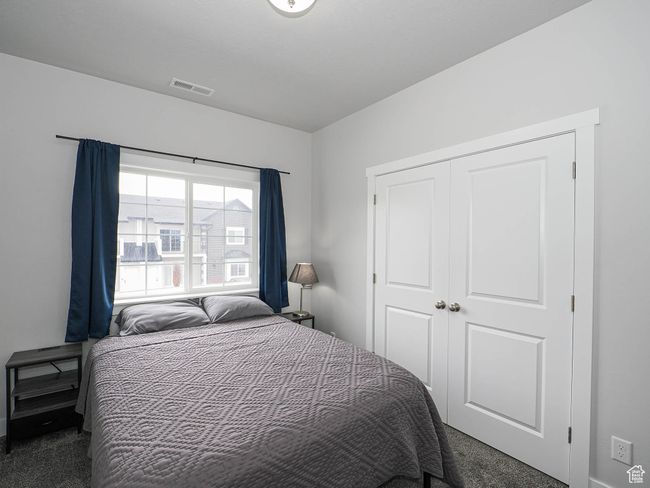 Carpeted bedroom with a closet and visible vents | Image 24