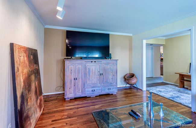 Living room with ornamental molding and dark wood-type flooring | Image 20