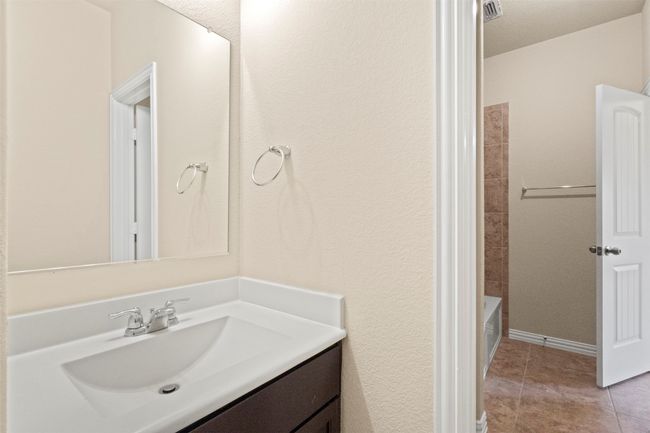 Bathroom with vanity, tile patterned flooring, and shower / bath combination | Image 23