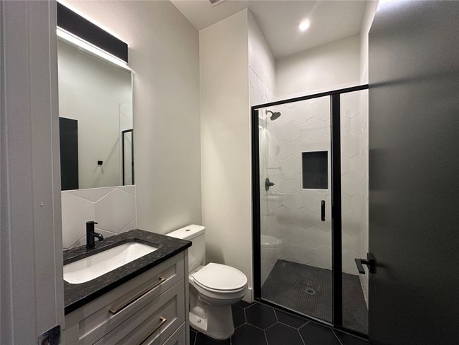 Bathroom with tile patterned flooring, vanity, and a stall shower | Image 32