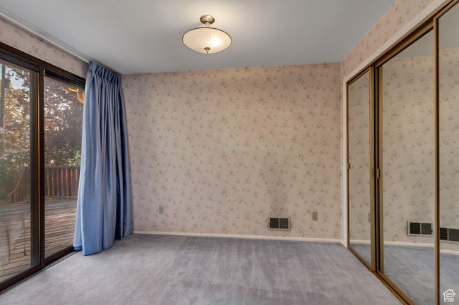 Empty room with a wealth of natural light, visible vents, and carpet | Image 12