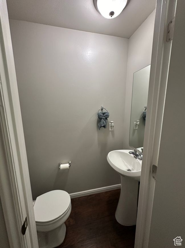 Bathroom featuring a sink, toilet, wood finished floors, and baseboards | Image 10