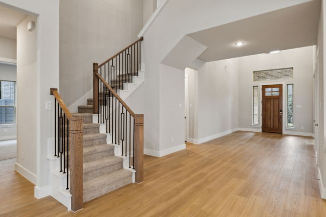 Foyer entrance featuring wood finished floors, healthy amount of natural light, stairs, and a high ceiling | Image 8