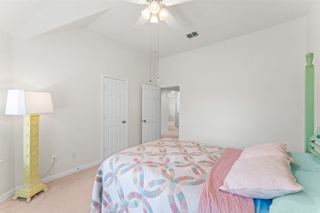 Bedroom featuring light colored carpet, a ceiling fan, and high vaulted ceiling | Image 30