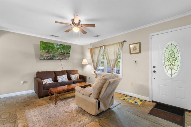 Living room featuring ornamental molding, a ceiling fan, and wood finished floors | Image 12