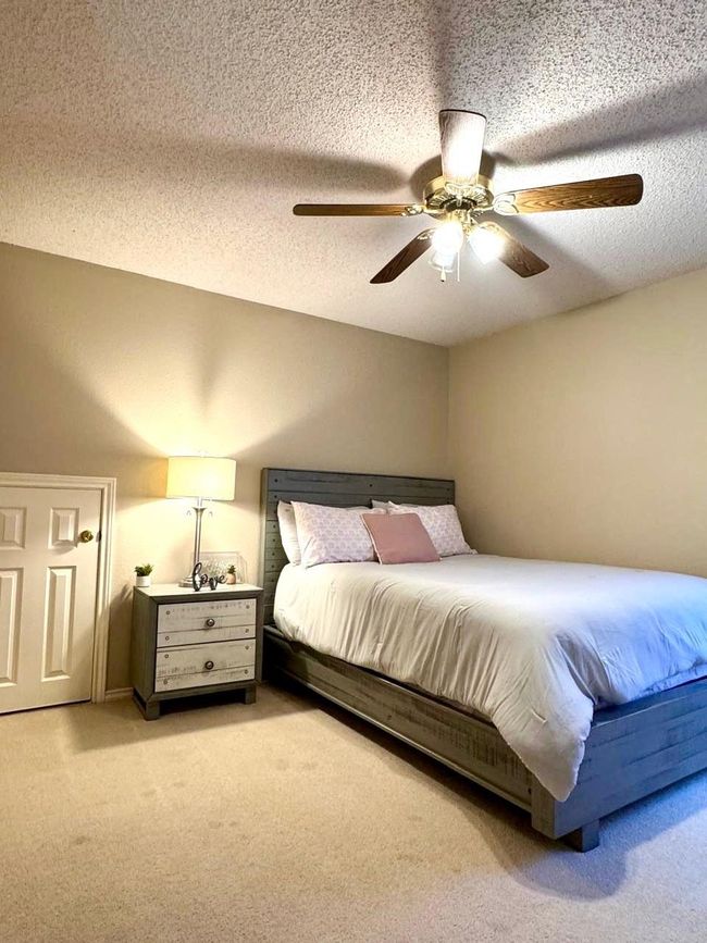 Bedroom with light colored carpet, a textured ceiling, and a ceiling fan | Image 14