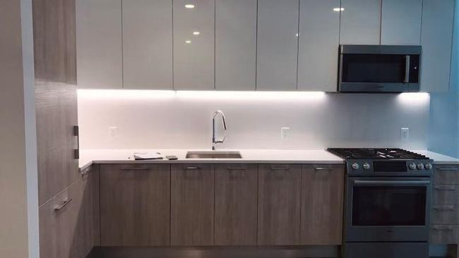 Kitchen with appliances with stainless steel finishes, modern cabinets, light countertops, and tasteful backsplash | Image 7