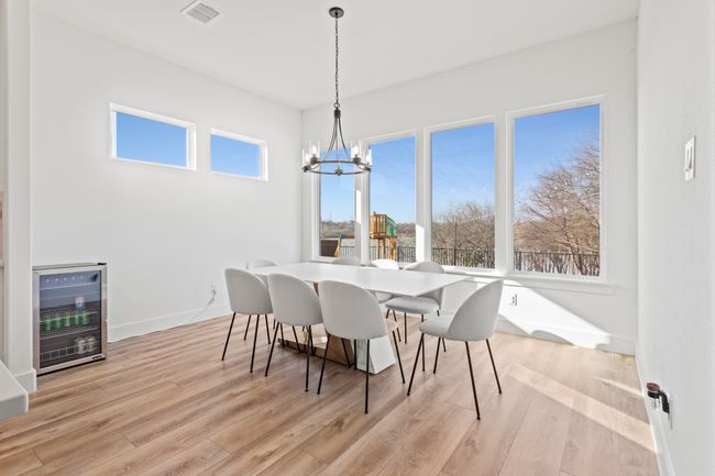 Dining space with beverage cooler, a chandelier, and light wood-style floors | Image 8