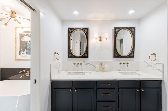 This stylish secondary bathroom has dual sinks with a standalone soaking tub and shower. | Image 36