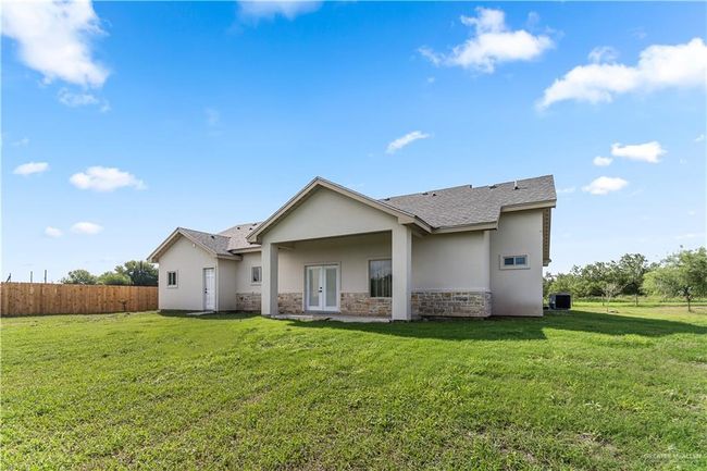 Rear view of property featuring a yard and central AC | Image 8