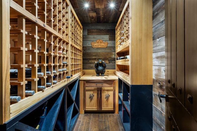Wine cellar featuring dark wood-style floors and wood walls | Image 23