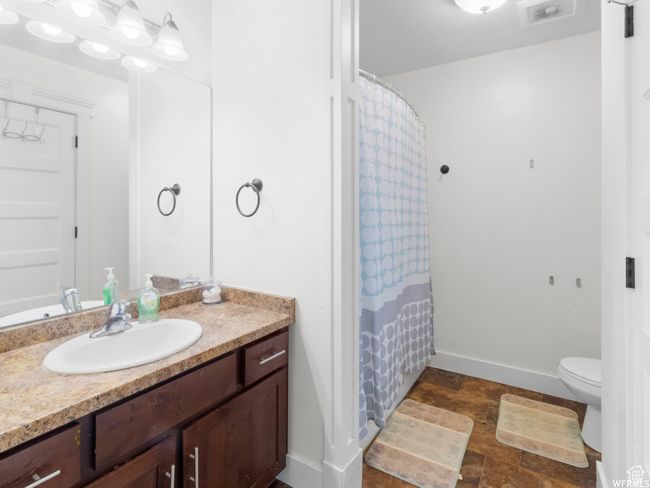 Full bathroom featuring vanity, toilet, baseboards, and a shower with curtain | Image 13