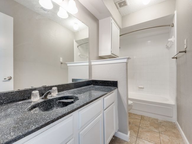 Bathroom featuring vanity and bathtub / shower combination | Image 10