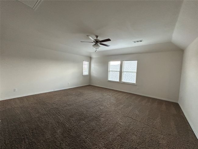 Empty room with dark carpet, ceiling fan, and baseboards | Image 24