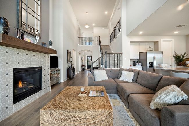 Living area featuring stairway, wood finished floors, arched walkways, a towering ceiling, and a fireplace | Image 16