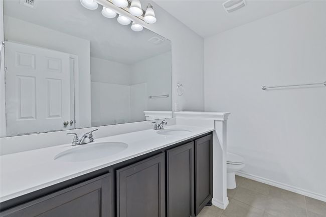 Bathroom featuring double vanity, tile patterned flooring, and a shower | Image 26