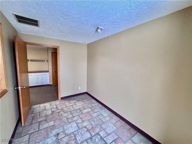 Spare room featuring a textured ceiling | Image 6
