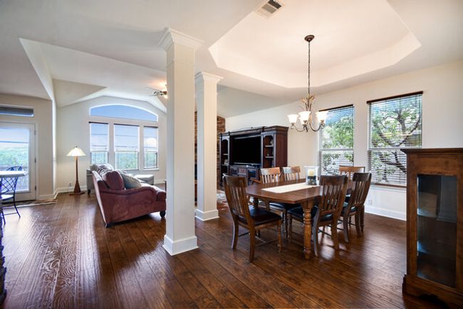 Dining room with a tray ceiling, decorative columns, plenty of natural light, and dark wood finished floors | Image 5