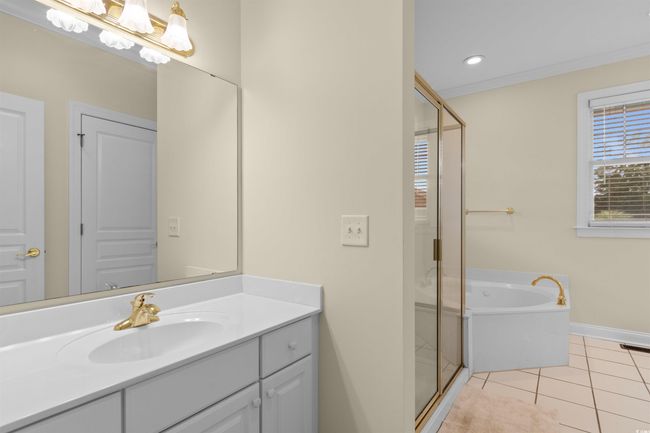 Full bathroom featuring a shower stall, vanity, a garden tub, baseboards, and tile patterned floors | Image 16