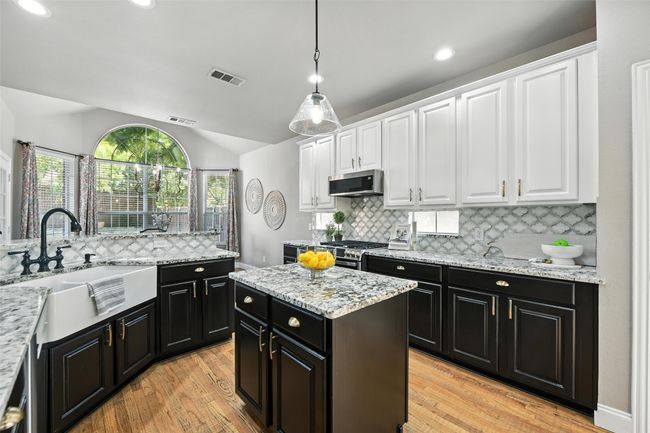 Kitchen featuring dark cabinetry, vaulted ceiling, white cabinets, tasteful backsplash, and recessed lighting | Image 10