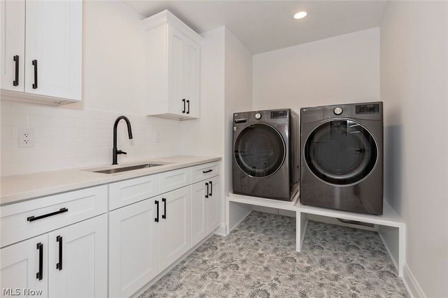 Washroom featuring washer and dryer, cabinets, sink, and light tile floors | Image 45