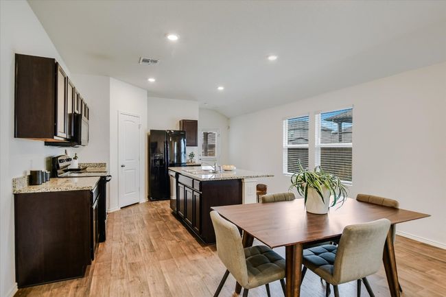 Kitchen with visible vents, a sink, dark brown cabinetry, and stainless steel appliances | Image 5