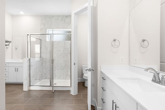Full bathroom with toilet, vanity, a marble finish shower, and tile patterned floors | Image 15