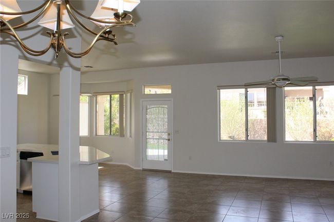 Tiled entryway featuring visible vents, baseboards, and ceiling fan with notable chandelier | Image 15