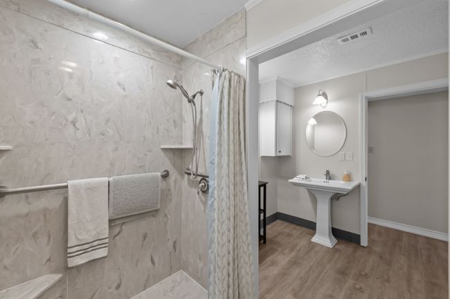 Full bathroom featuring baseboards, a shower with shower curtain, a textured ceiling, visible vents, and wood finished floors | Image 27