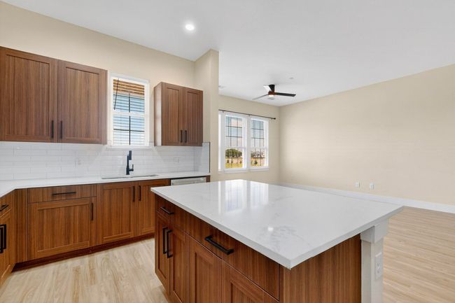 Kitchen featuring light wood-style floors, ceiling fan, healthy amount of natural light, tasteful backsplash, and recessed lighting | Image 19