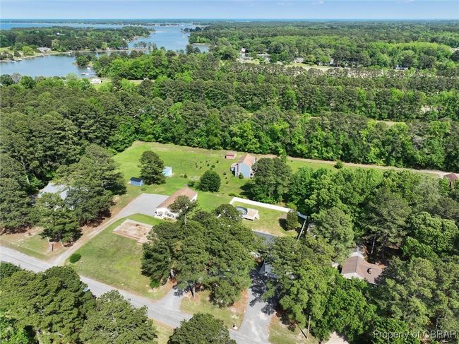 Aerial view of property and surrounding area featuring a nearby body of water and a heavily wooded area | Image 40