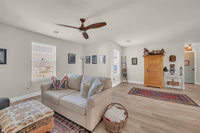 Loft space currently being used as a Living area featuring wood finished floors, recessed lighting, baseboards, and ceiling fan | Image 13