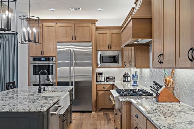 Kitchen with built-in Jenair refrigerator and double ovens. | Image 14