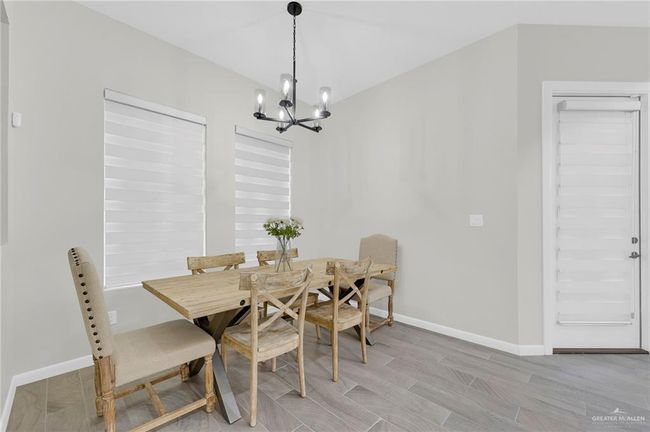 Dining room with baseboards, wood-style tile flooring, and a notable chandelier | Image 13