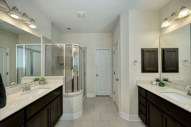 Bathroom with two vanities, and a large shower with a convenient bench. | Image 13