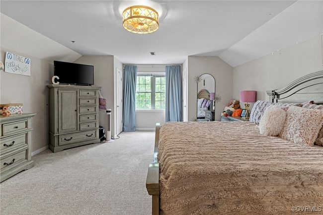Bedroom with light colored carpet, vaulted ceiling, and baseboards | Image 34