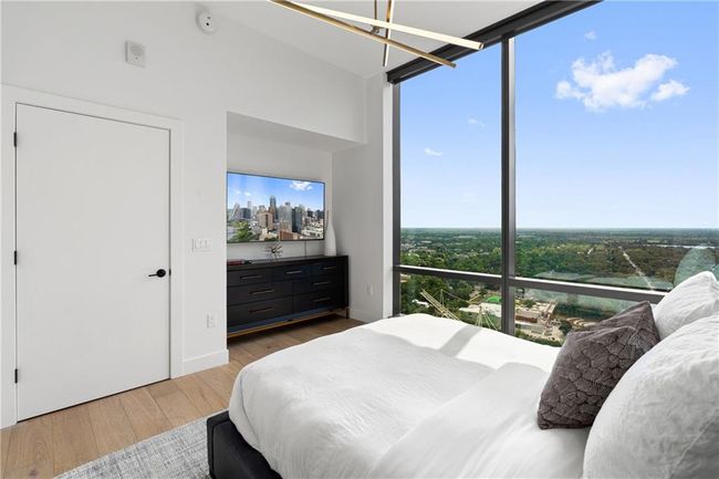 Bedroom with a wall of windows, baseboards, and wood finished floors | Image 15