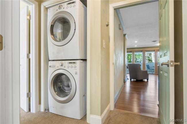 Laundry area with baseboards, carpet flooring, stacked washer and dryer, and laundry area | Image 20